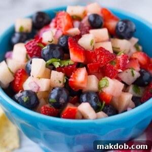 A refreshing bowl of 4th of July Fruit Salsa, brimming with red strawberries, white jicama, and blue blueberries.