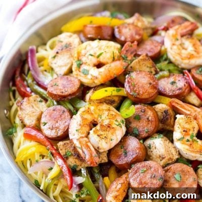 A top-down view of a bowl of creamy Cajun Jambalaya Pasta, showcasing the shrimp, chicken, andouille sausage, and bell peppers, perfect for a recipe card image.