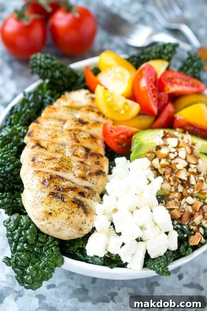 Tuscan kale salad with red and yellow tomatoes and sliced grilled chicken.