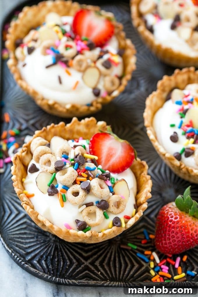 A close-up view inside a waffle cone cup revealing layers of creamy vanilla yogurt and crunchy Cheerios cereal, ready for more toppings.