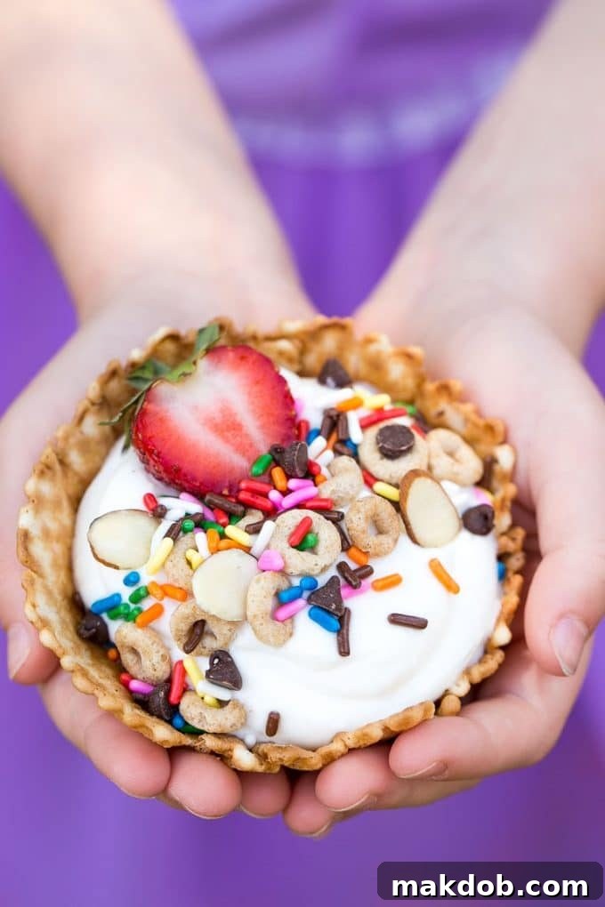 Children's hands eagerly holding a freshly assembled breakfast sundae, showcasing the joy of customizing their morning meal.