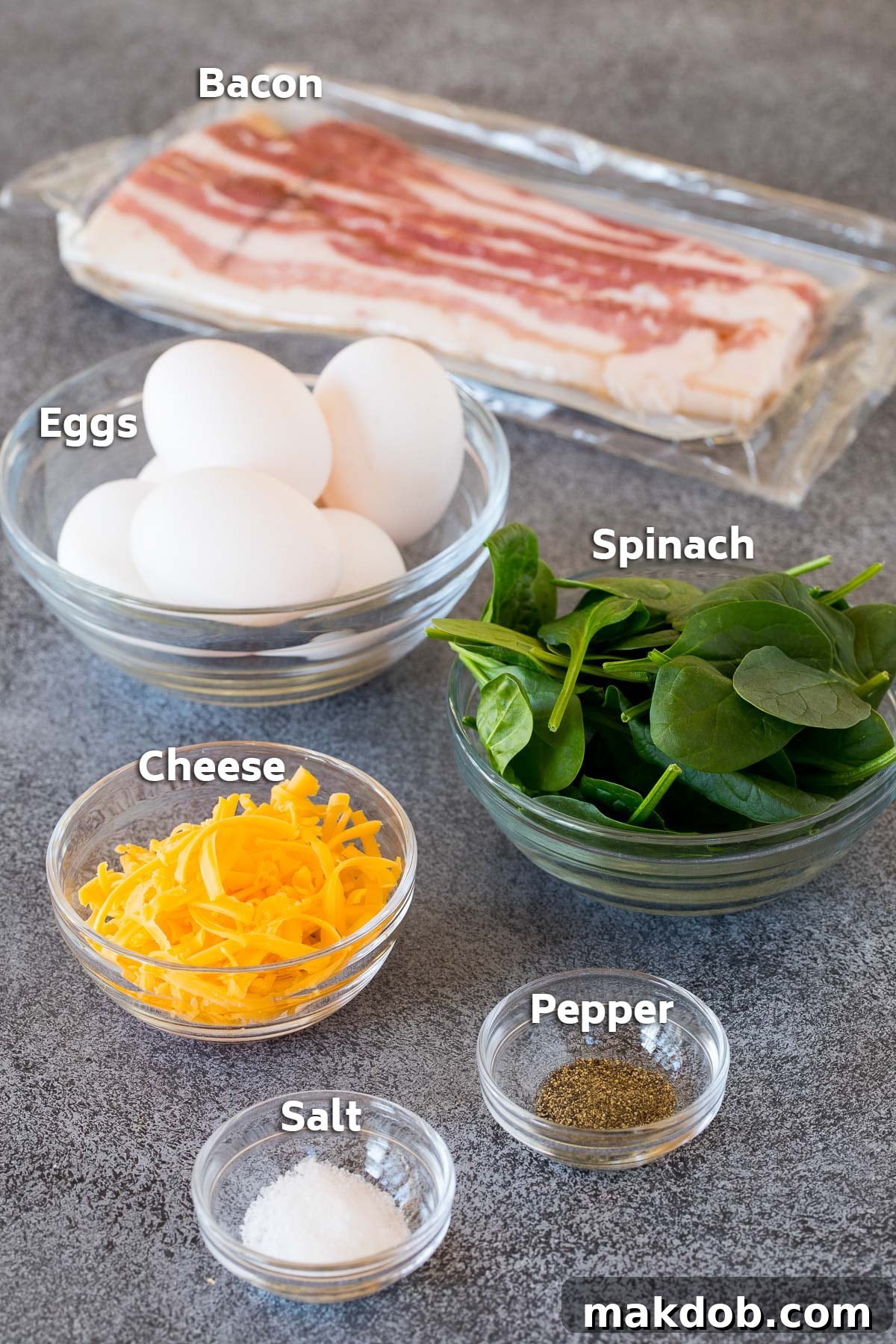 Morning Protein Muffins 3 A vibrant display of ingredients including fresh eggs, crisp spinach, rich cheddar cheese, and savory bacon bits, ready to be transformed into delicious breakfast egg muffins.