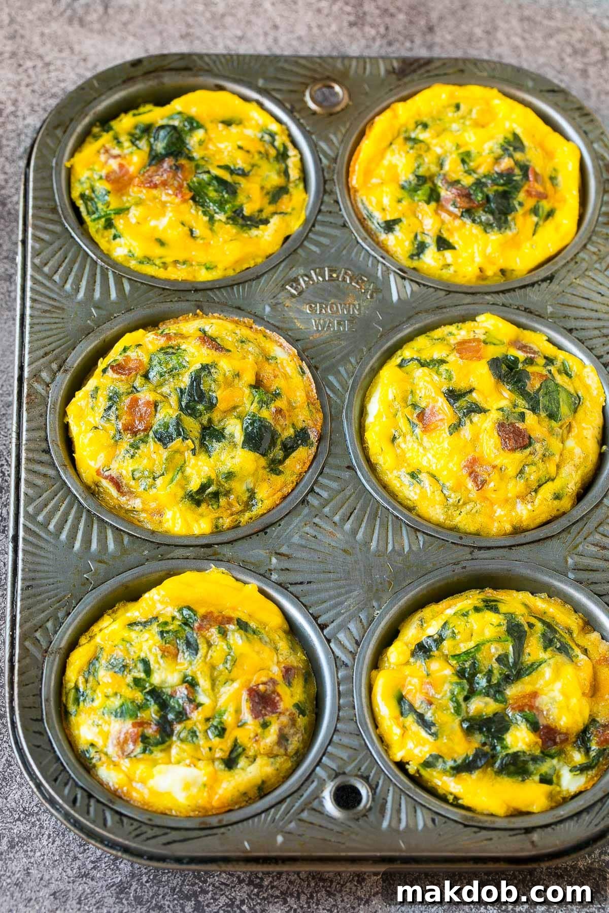 Morning Protein Muffins 5 Cooked egg cups resting in a muffin tin, perfectly browned and ready to be served or stored for later.