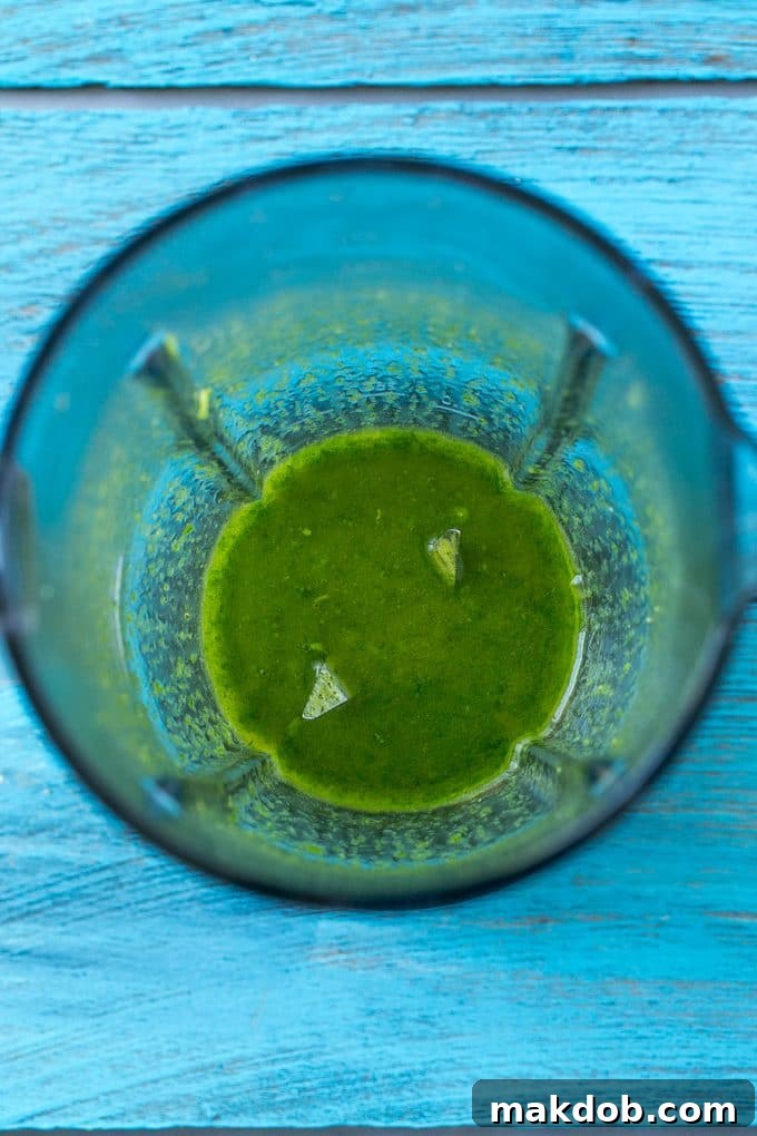 Fresh Cilantro Lime Sauce Pureed cilantro, lime, garlic, and olive oil sauce in a blender, ready to marinate chicken.