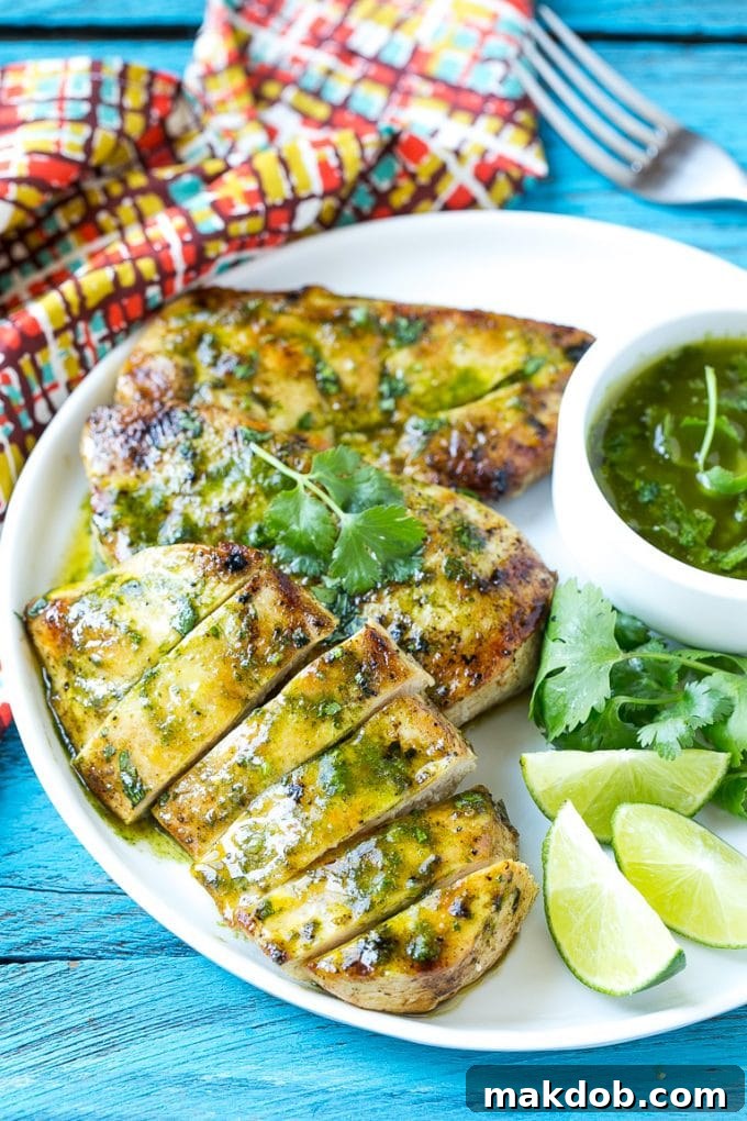 Cilantro Lime Chicken Ready to Serve Sliced cilantro lime chicken on a serving plate, garnished with fresh cilantro and lime wedges, showcasing its tenderness and vibrant flavors.
