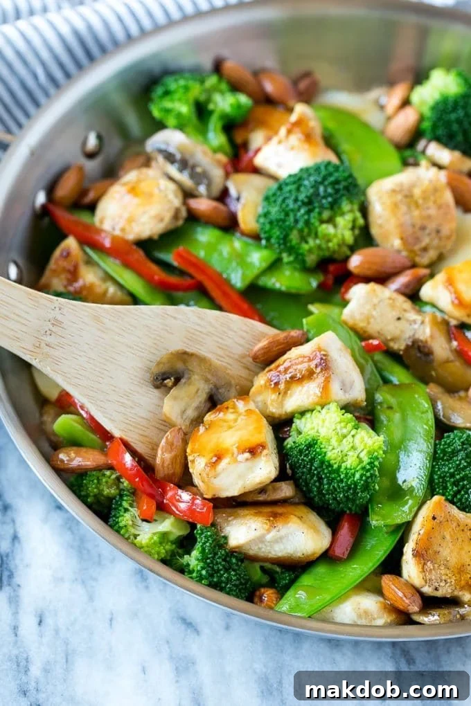 A pan of chicken almond ding with a serving spatula in it.