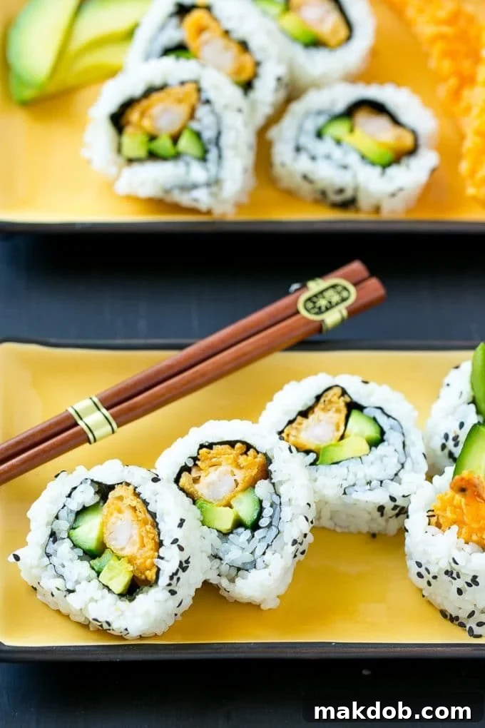 Shrimp Tempura Sushi Roll | Shrimp Tempura Sushi | Shrimp Sushi #sushi #tempura #shrimp #dinner #dinneratthezoo Shrimp tempura sushi wrapped in seaweed and rice and garnished with sesame seeds.