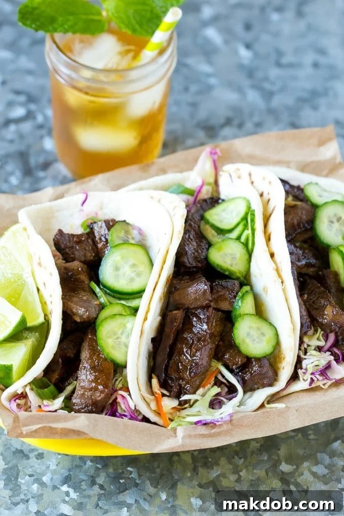 A beautifully presented basket of Korean beef tacos, served alongside refreshing iced tea, ready for a delicious meal.