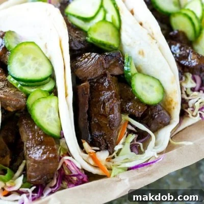 This recipe for Korean BBQ Tacos features marinated and seared beef, cabbage slaw, and marinated cucumbers in warm flour tortillas.
