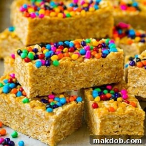 Cereal bars stacked on a sheet pan topped with colorful sprinkles.