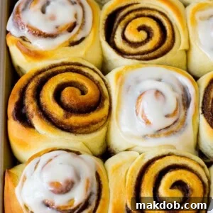Homemade cinnamon rolls, some with frosting on top.