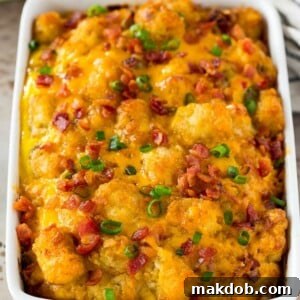 Tater tot breakfast casserole topped with bacon and green onions.