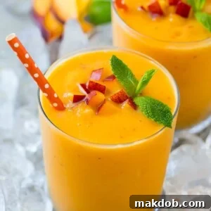 A peach smoothie in ice garnished with mint.