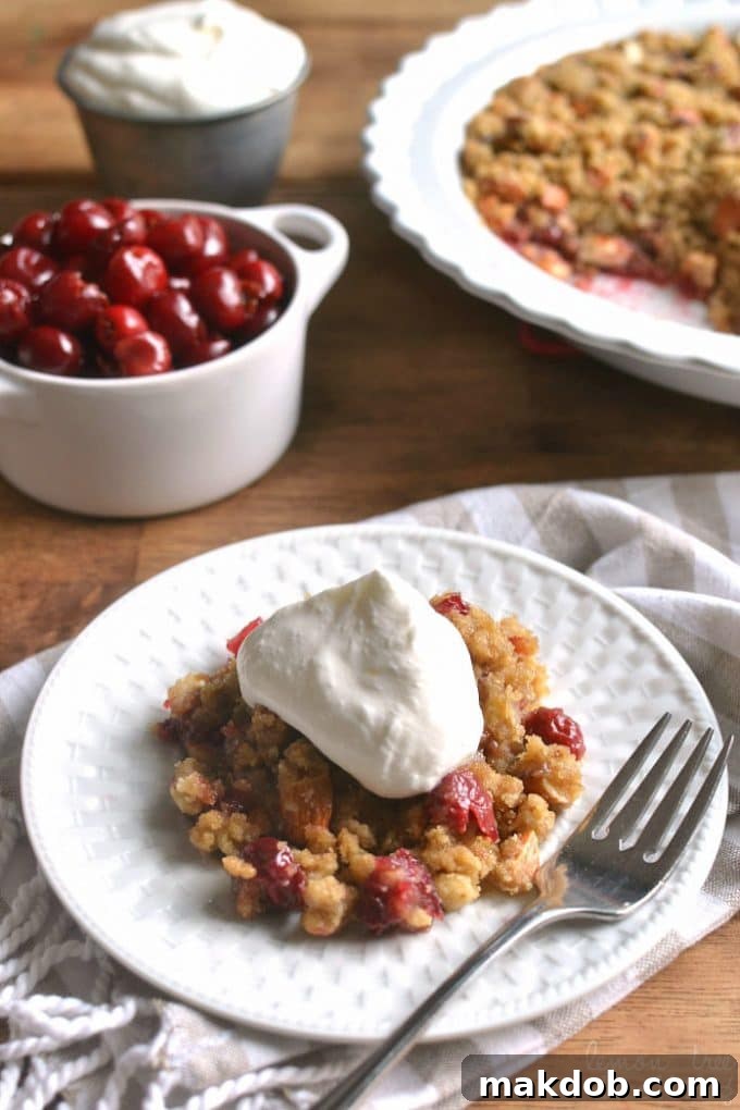 Delicious Cherry Almond Crisp dessert, served warm with ice cream.