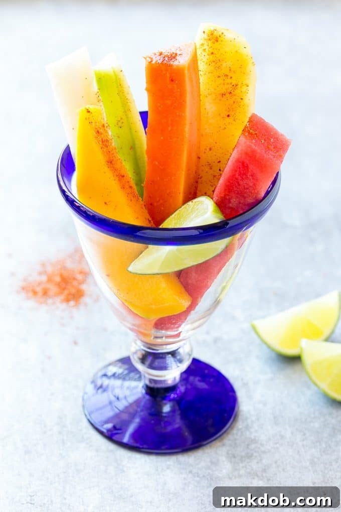Mexican fruit cups topped with chili lime seasoning and fresh lime.
