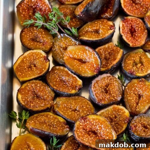 Luscious Roasted Figs 8 Roasted figs on a sheet pan, garnished with sprigs of thyme.