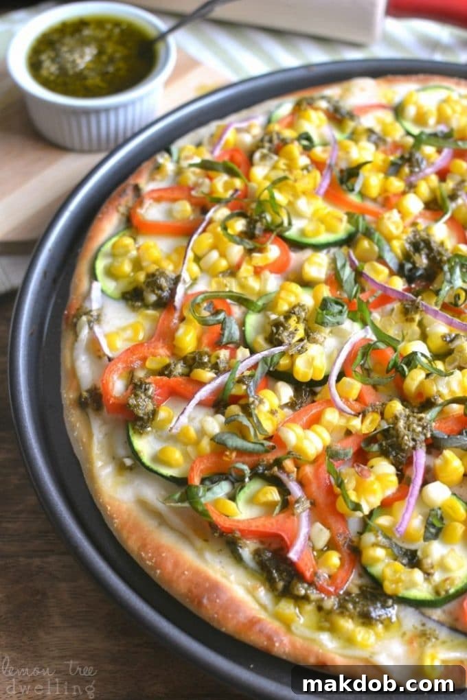 Fresh Garden Vegetable Pesto Pizza with colorful toppings and a golden crust