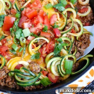 Zucchini noodles mixed with Mexican taco-style meat, cheese, and fresh vegetables.