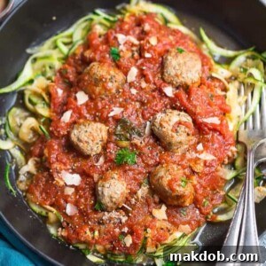 A hearty plate of zucchini noodles with savory meatballs and marinara sauce.
