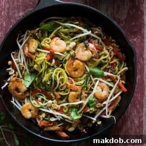 A skillet filled with vibrant zucchini noodle pad Thai.