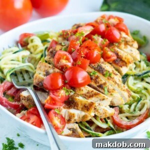 A plate featuring spicy Cajun chicken zucchini noodles with bell peppers.