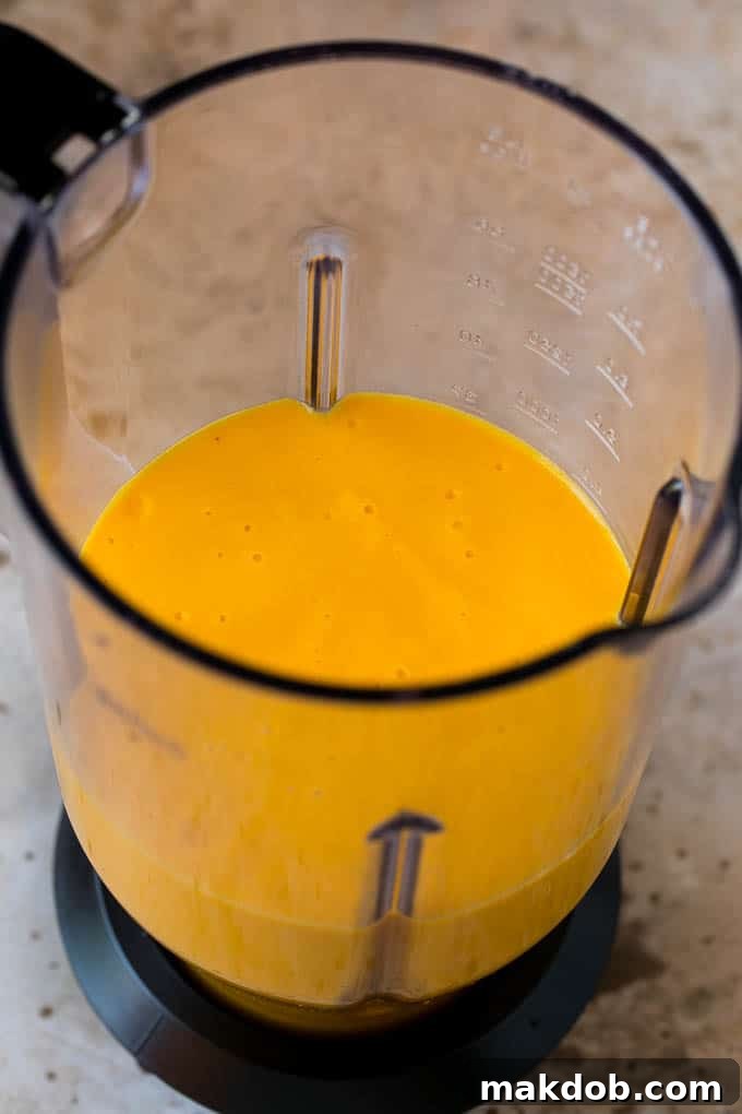 Blended Smoothie | Perfect Consistency A creamy, blended tropical smoothie swirled inside a high-speed blender, ready to be poured.