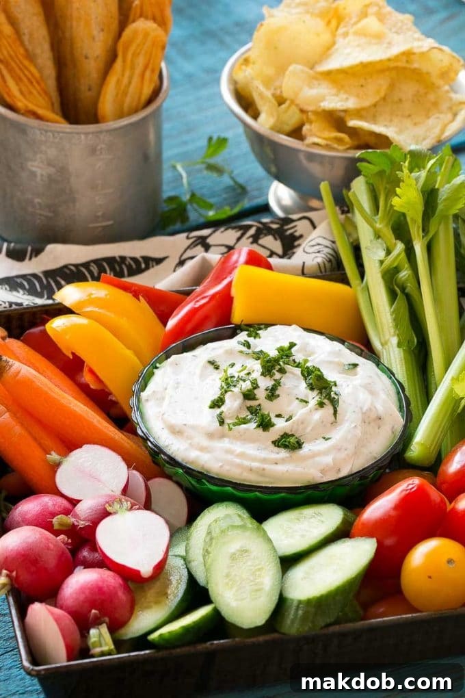 Homemade Ranch Dip Recipe | Homemade Ranch Powder | Homemade Ranch Dressing | Best Ranch Dip #ranch #dip #appetizer #snack #dinneratthezoo A vibrant and appetizing platter filled with an abundant selection of fresh, colorful vegetables such as crisp carrots, bright green celery, leafy broccoli florets, and colorful bell pepper strips, all beautifully arranged around a central green bowl overflowing with creamy homemade ranch dip. This spread is perfect for a festive gathering or a healthy snack.