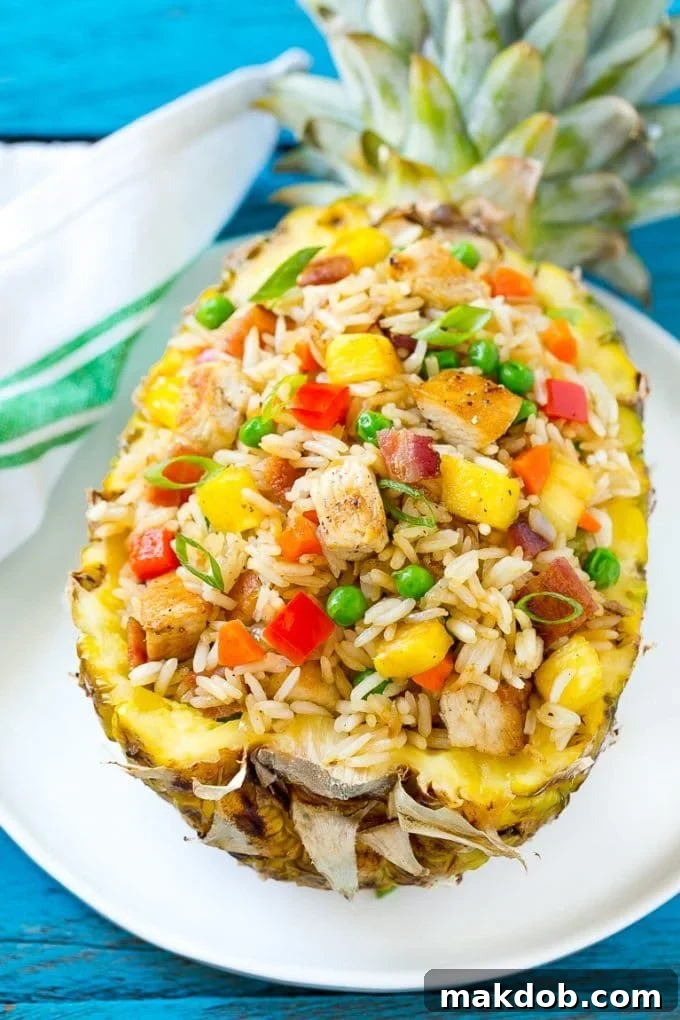 Pineapple fried rice presented elegantly in a hollowed-out pineapple, garnished with green onions and lime, highlighting its potential for a stunning presentation.