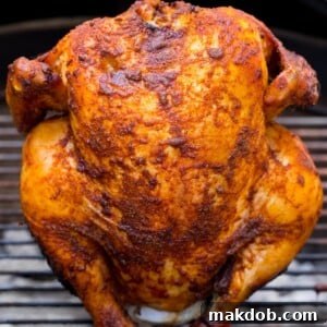 A whole beer can chicken roasting perfectly on the grill, ready for a delicious feast.