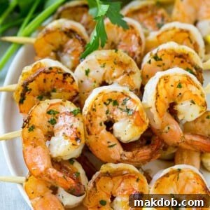 Perfectly grilled shrimp skewers, garnished with fresh lemon wedges and vibrant parsley.