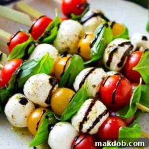 Elegant Caprese Skewers, featuring fresh cherry tomatoes, basil leaves, and mozzarella balls.