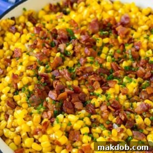 Golden fried corn, generously topped with crispy bacon and fresh chives, served in a skillet.