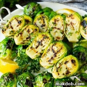 Perfectly grilled Brussels sprouts on skewers, elegantly served with fresh lemon and parsley.