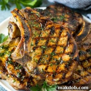 Perfectly grilled pork chops, beautifully seared and garnished with fresh parsley.