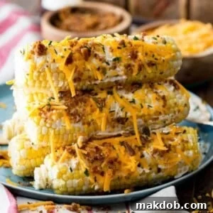 An inviting image showcasing a stack of cheddar bacon corn on the cob, lavishly topped and ready to be enjoyed as a savory treat.