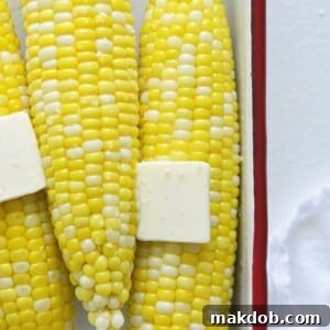 A single ear of perfectly cooked microwave corn on the cob, topped with a melting pat of butter. The image emphasizes the simplicity and speed of this cooking method, promising juicy, flavorful corn with minimal effort, ideal for quick meals or when time is of the essence.