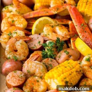 A generous Low Country Boil spread across a large sheet pan, featuring succulent shrimp, seasoned crab legs, smoky sausage, vibrant corn on the cob, and tender potatoes. This colorful and abundant display promises a hearty, flavorful feast perfect for feeding a crowd and embodies classic Southern comfort food.