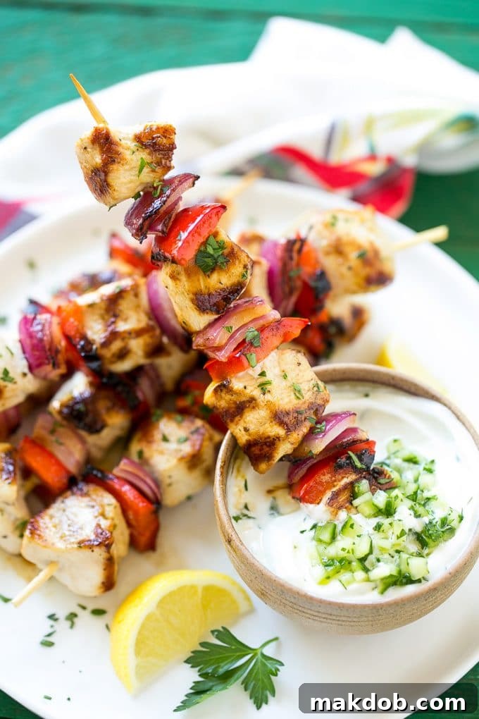 Greek Chicken Kabobs | Grilled Chicken Kabobs | Healthy Chicken Recipe | Greek Chicken #greekfood #chicken #grilling #grilledchicken #kabobs #dinner #dinneratthezoo A close-up of a Greek chicken kabob being dipped into a bowl of creamy cucumber yogurt sauce, highlighting the perfectly grilled chicken and fresh vegetables.