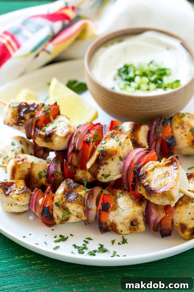 Greek Chicken Kabobs | Grilled Chicken Kabobs | Healthy Chicken Recipe | Greek Chicken #greekfood #chicken #grilling #grilledchicken #kabobs #dinner #dinneratthezoo A plate of Greek style chicken kabobs, generously topped with fresh chopped parsley and garnished with bright lemon wedges, ready to be served.