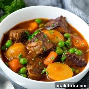 A comforting bowl of Instant Pot beef stew brimming with tender meat, chunky potatoes, carrots, onions, and sweet peas in a rich, flavorful broth.