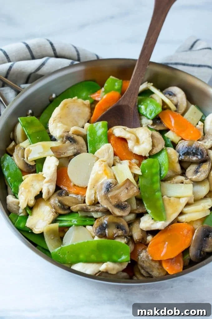 Moo goo gai pan with chicken and vegetables in a skillet. A classic, healthy chicken and mushroom stir fry recipe perfect for homemade Chinese food night.
