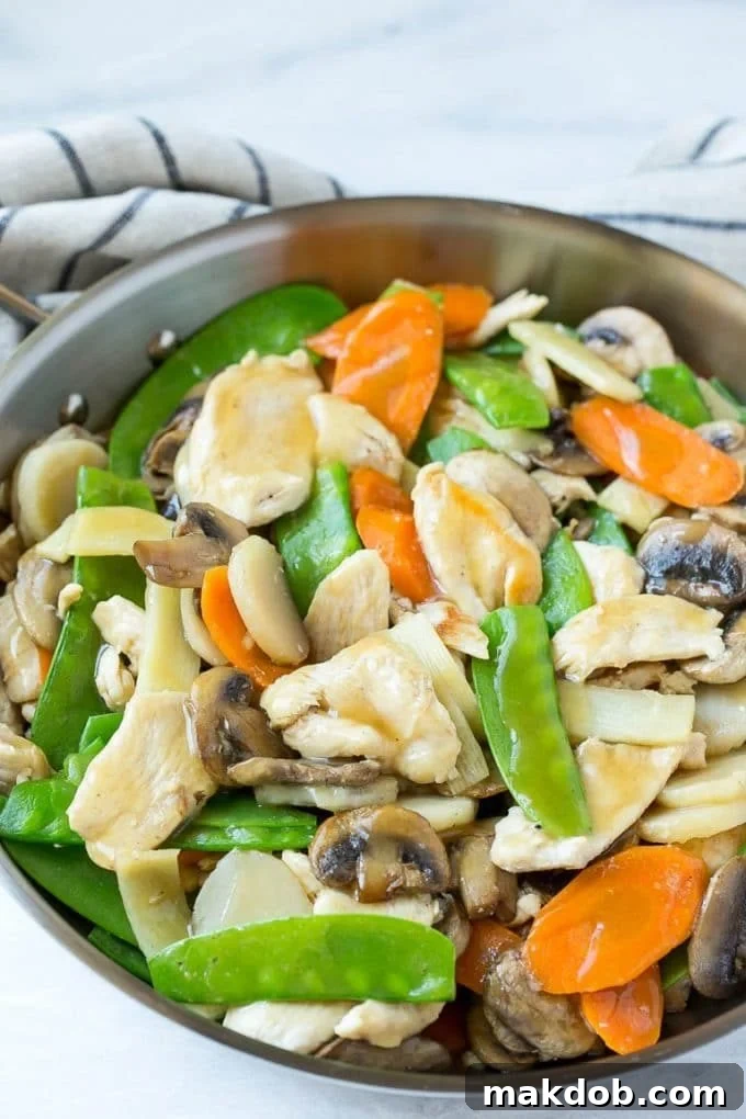 Chicken, vegetable and mushroom stir fry in a pan. A delicious and healthy homemade stir fry option for Chinese food lovers.