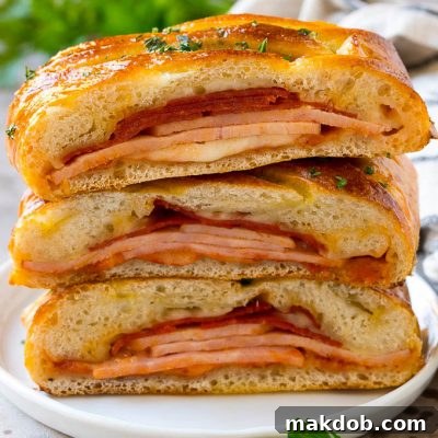 A stromboli recipe with pepperoni, ham and cheese wrapped up in pizza dough and baked.