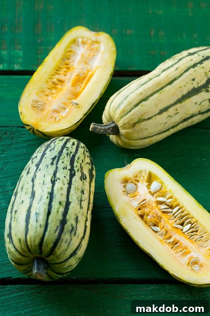 Raw delicata squash on a green board.