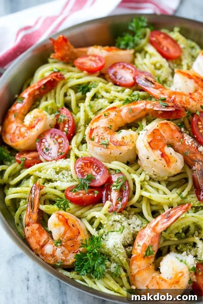 Seared shrimp served over spaghetti tossed in pesto sauce.