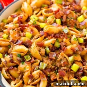 A comforting pan of cheeseburger pasta, featuring ground beef, onions, pasta shells, cheddar cheese, and bacon.