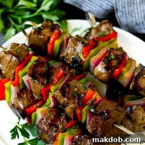 Flavorful shish kabobs featuring tender beef, crisp bell peppers, and sweet onions, all perfectly skewered and presented on a serving plate.
