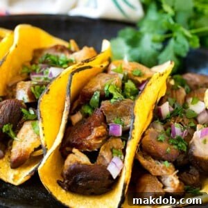 Delicious slow cooker carnitas tacos, generously filled with tender meat, fresh onions, and fragrant cilantro.