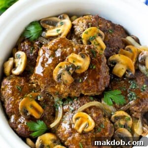 Hearty slow cooker Salisbury steak, generously topped with savory mushroom gravy and caramelized onions.
