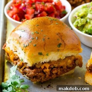 Delicious taco sliders served with vibrant salsa and creamy guacamole on the side, perfect for a party.